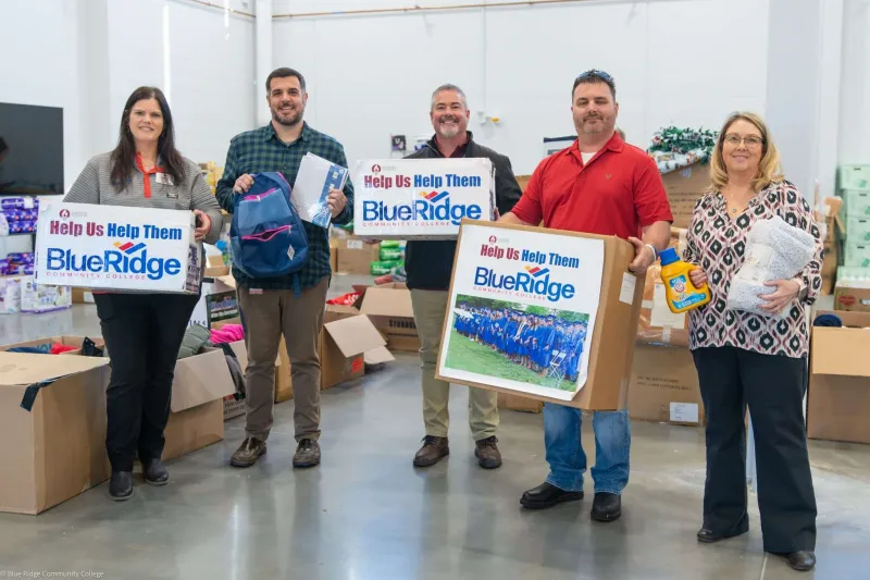 Group of people hold donated boxes to Blue Ridge Community College.