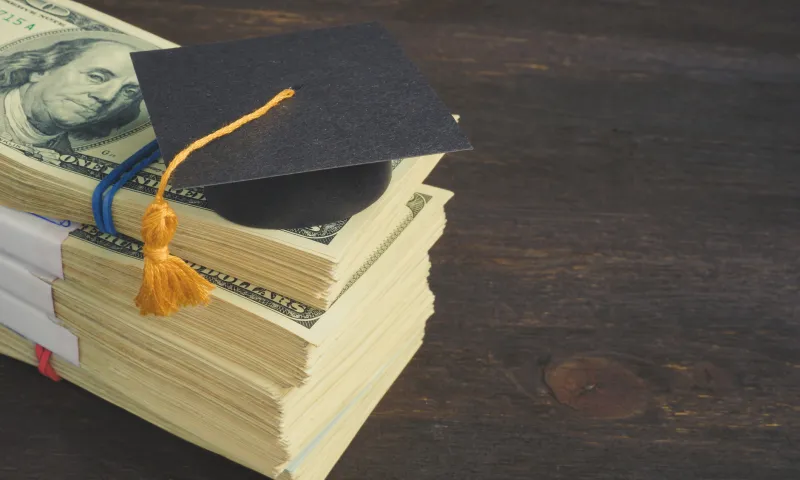 Grad cap on stack of money