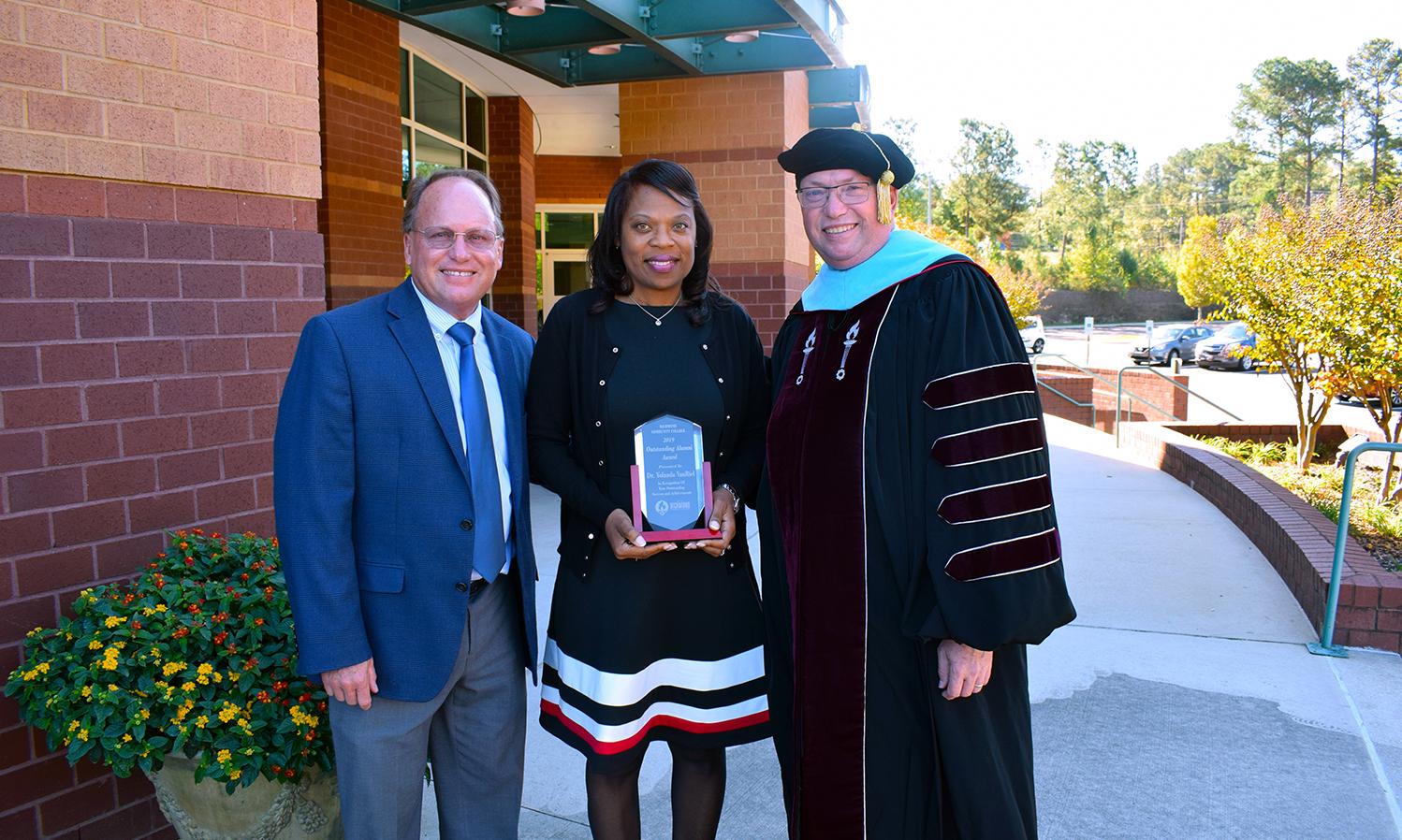 Dr. VanRiel stands with college leaders