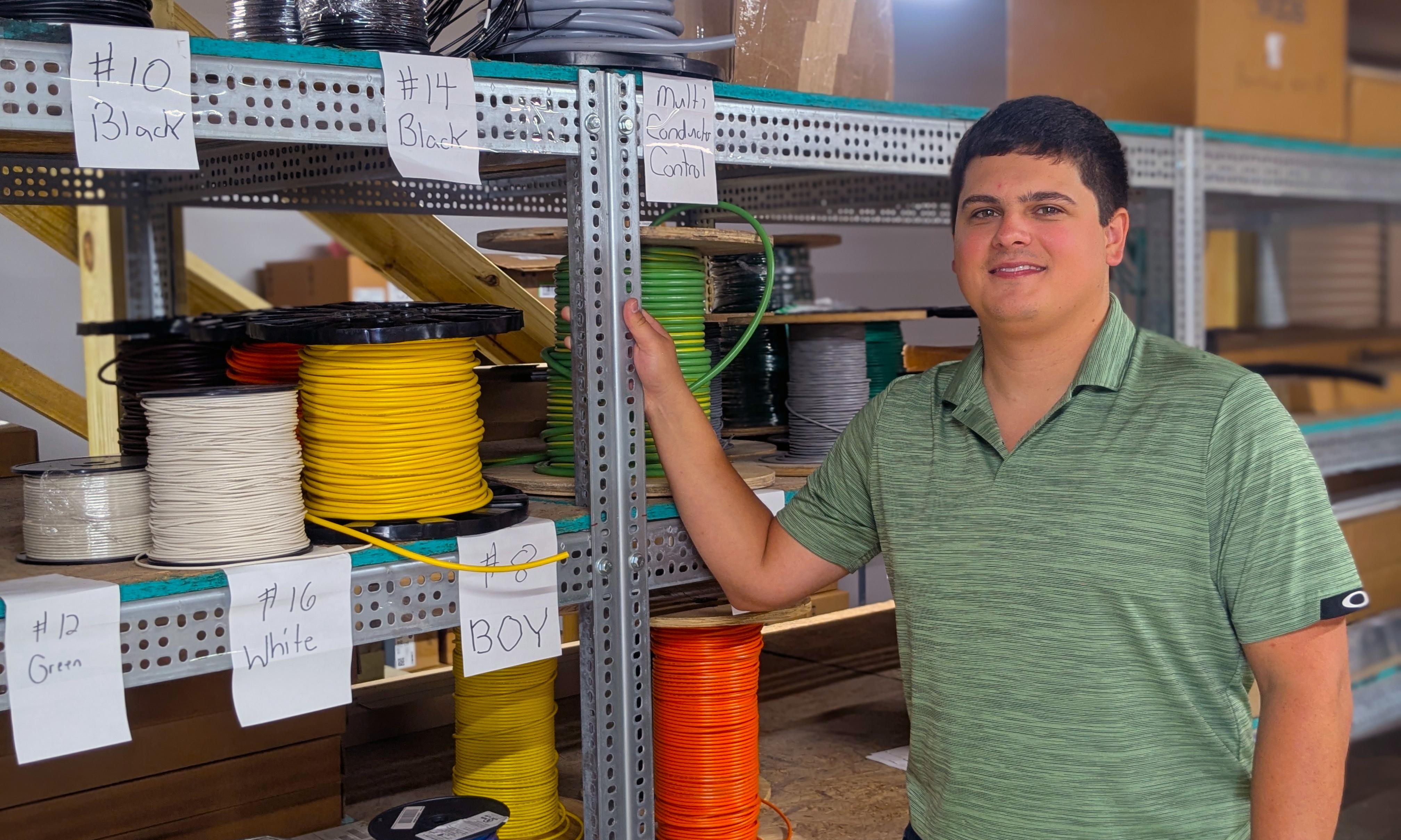 Ricky McRae stands next to spools of wire